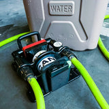 Water pump with green hoses next to a tan container labeled 'WATER'.