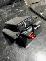 Black electronic device with cable on a table dark background