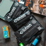 cana provisions personal packets on a surface with a book and other items.